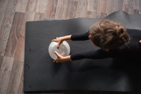 Small child girl 4 5 years old doing gymnastics training in the studio class, healthy active education. Yoga, dancing or gymnastics for kidsの写真素材