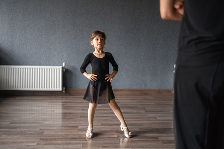 Child girl standing in black sport bodysuit in dancing studio during training posture. 4 5 years old preschool age. Healthy physical developmentの写真素材