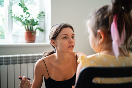 makeup artist doing kids makeup with pink eyeliner. Small girl party or birthday day preparation.の写真素材