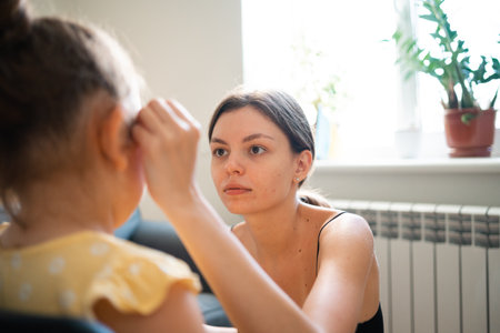 makeup artist doing kids makeup with pink eyeliner. Small girl party or birthday day preparation.の写真素材