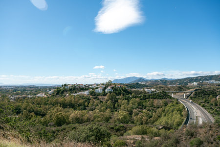 Scenic view of countryside landscape with road and hills under blue skyの写真素材