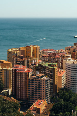 Coastal cityscape with vibrant buildings overlooking the serene sea.の写真素材