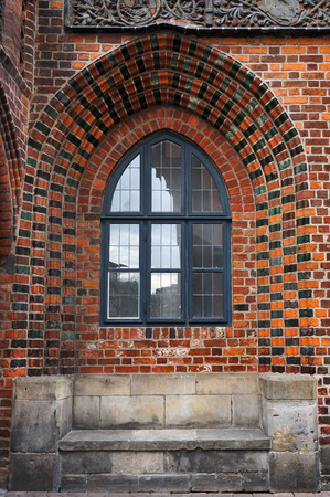 Stone bench and lancet window in brick wall of Old Town Hall in Hannover, Germany.の写真素材