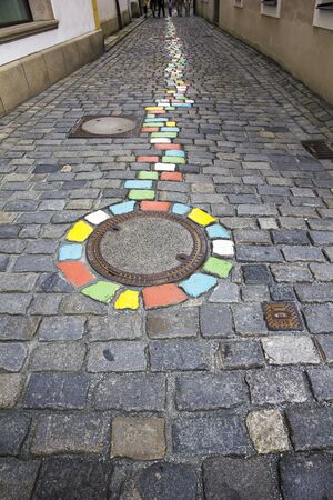 Passau, Germany - August 10, 2012: Colored manhole cap and pavement on the narrow street of old town in Passau.のeditorial素材