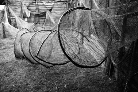 Old fishing nets hanging on a wooden wall.                                 