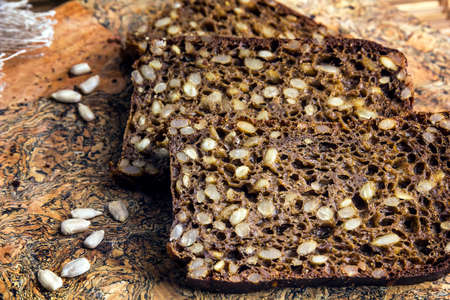 Slices of black rye bread baked with sunflower seeds.