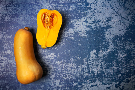 Fresh raw ripe pumpkin sort Butternut squash with copy space on grunge blue background.の写真素材