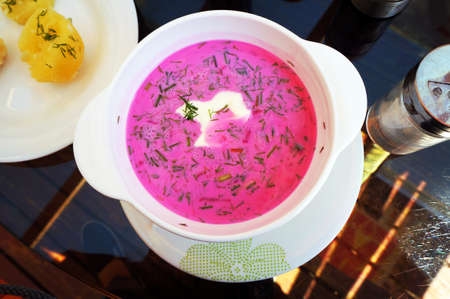 Cold beetroot soup with sour cream, greens and hot potatoes. Top view. Selective focus.の写真素材