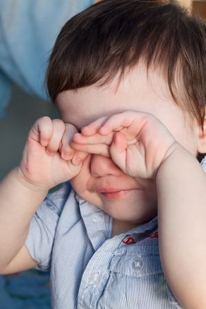 Child closed his eyes with his hands and crying