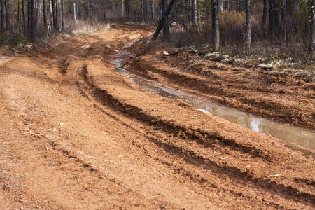 Dirt road with mud and big puddlesの写真素材