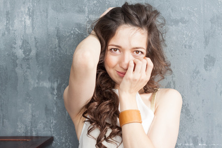 Portrait of caucasian a girl with curly hair on a gray backgroundの写真素材