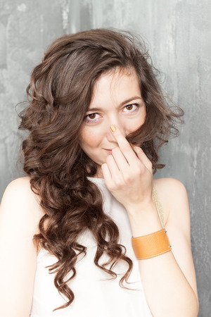 Portrait of caucasian a girl with curly hair on a gray backgroundの写真素材