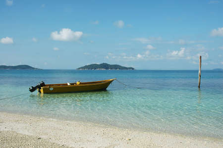boat at sea side with clear water and blue skyの写真素材