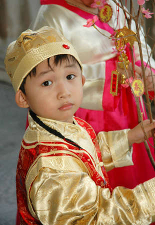 young chinese kid wearing traditional costume and hatの写真素材
