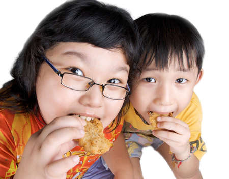 two kids eating fish and chips snackの写真素材