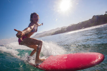 Surfer girl surfs a wave in Indian ocean.
