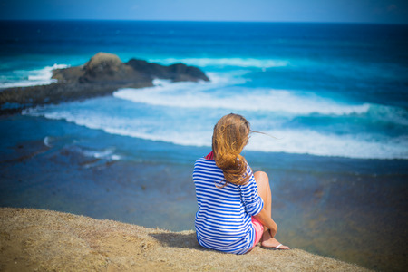Girl Sitting on the Beach Wearing Sunglasses