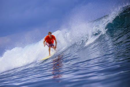 Surfer on Amazing Blue Wave, Bali island.