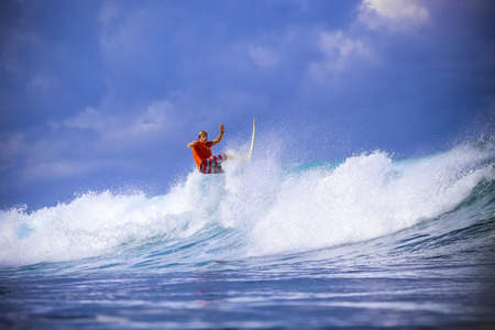 Surfer on Amazing Blue Wave, Bali island.
