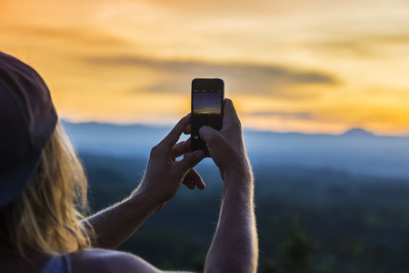 Man with Mobile Phone and Volcano Agung as Background.at Sunrise Time,Bali,Indonesia.