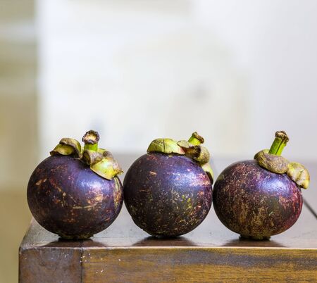 Mangostins and Fresh Green Leaf on Wooden Table