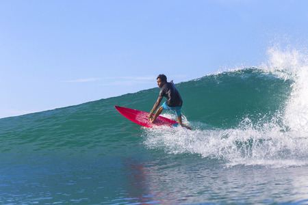 Surfer on Amazing Blue Wave, Bali island.