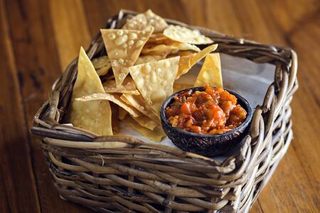 Chips nachos with salsa sauce on a wooden tableの写真素材