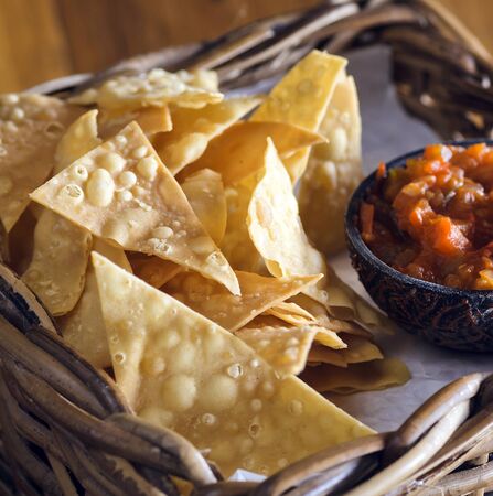 Chips nachos with salsa sauce on a wooden table