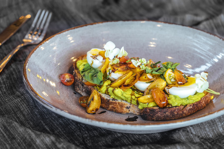 Avocado toast with cherry tomatoes and eggsの写真素材