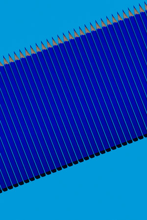 Pattern of dark blue pencils at blue background