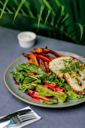Outdoors shot of sweet potato and salad on the tableの写真素材