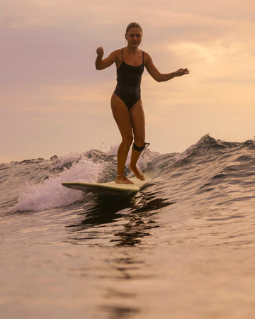 Woman Gliding Down Smooth Wave Face At Sunset, Forward Focus And Confident Footwork, Clean Water...