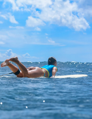 Young Woman Paddling Toward Distant Wave, Demonstrating Controlled Stroke Technique And Strong...