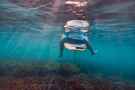 Surfer Sitting On Surfboard Underwater, Surf Instructor Taking Restorative Pause, Legs Dangling Above Kelpの写真素材
