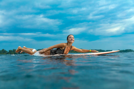 Young Woman Smiling During Sunrise Paddle On Board, Gentle Morning Light And Calm Sea With Focused...