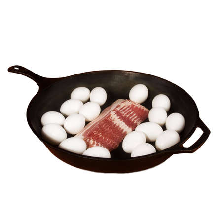 Cast Iron Frying pan with raw eggs and baconの写真素材