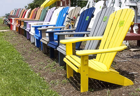 Lineup of colorful outside lawn wooden lawn chairs for sale on roadside