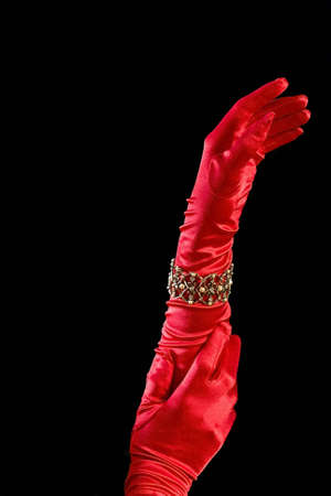 Arms and hands in air with long red silk gloves and decorative bracelet.の写真素材