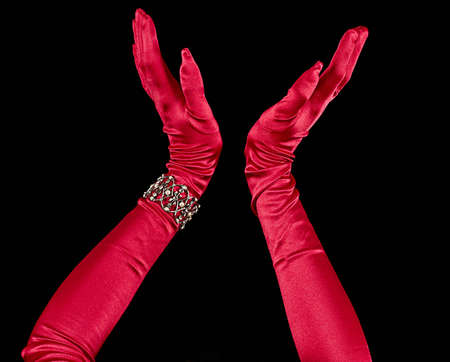 Red silk formal long length gloves with decorative bracelet with black backgroundの写真素材