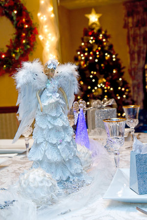 Beautiful and elegant table setting with lighted angels for Christmas Eve Dinnerの写真素材