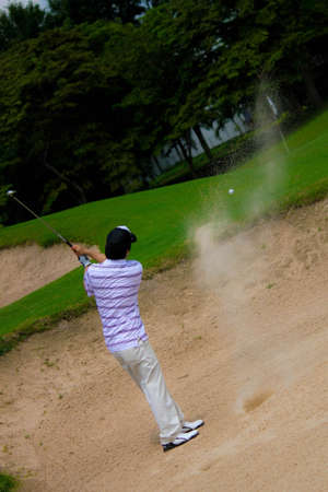 A man hit sand shot for on greenの写真素材