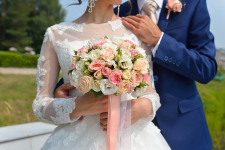 Just married couple embraced, and bride holding beautiful wedding flowers.の写真素材