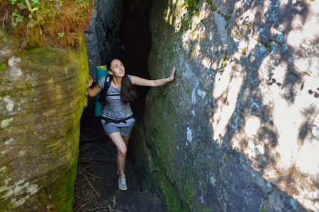 Woman Hiker Backpacker exploring narrow canyon in summer day.の写真素材