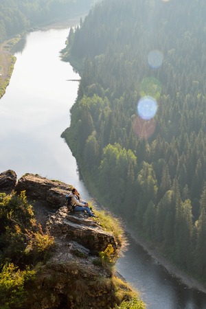 Young pretty woman sitting on top of mountain, relax, calm and meditation with nature.の写真素材