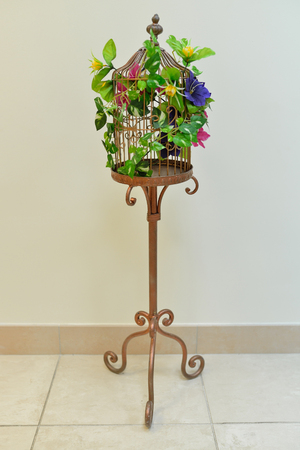 Vintage decorative birdcage with artificial flowers. Beautiful romantic decor.の写真素材