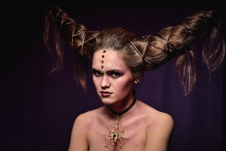 Woman in Halloween makeup with hairstyle in form of horns, Devil Queen.の写真素材