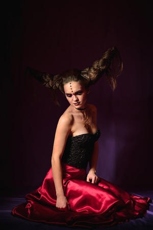 Studio portrait of woman in halloween makeup, on black background.の写真素材