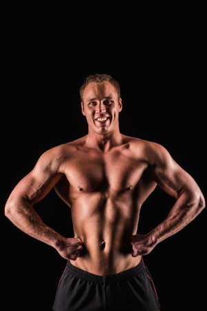 Sporty and healthy muscular strong man isolated on black background smiling.の写真素材