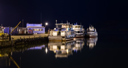 Lonely old ships on a city pier at night.の写真素材