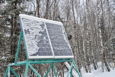 Solar panel plant under the snow in winter forest.の写真素材